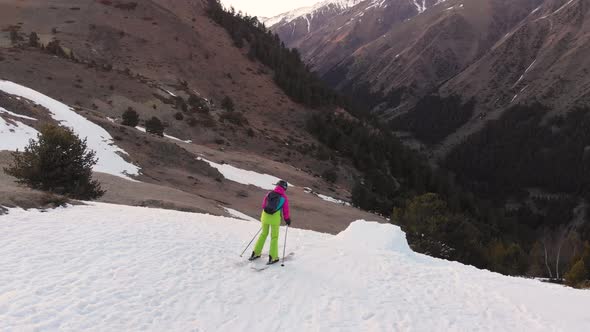 An Aerial View Lady Skier Jumps From a Snow Kicker in the Evening in the Mountains in the Spring