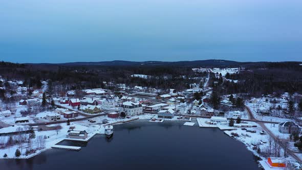 Aerial footage flying high over Moosehead Lake and a snow covered downtown Greenville Maine