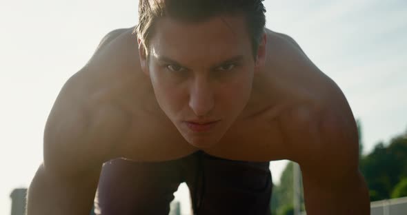 Young Muscular Concentrated Athlete Man Starting Running of the Treadmill at the Stadium