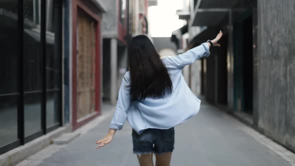 Attractive beautiful Asian woman traveler dancing in street celebrating vacation.