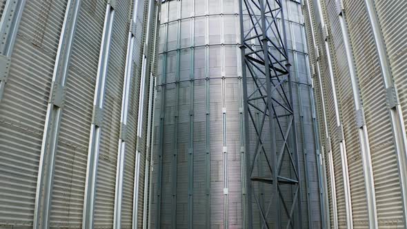 Exterior of modern plant. Large metal grain elevators outdoors. 