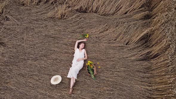 beautiful young woman in dress is lying on a wheat field. summer holiday concept. happy girl 