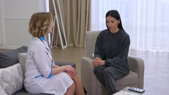 Young Woman Doctor Expressing Empathy to Patient During Consultation at Home