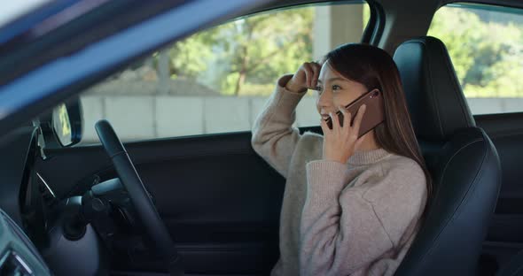 Woman talk to cellphone sit inside car