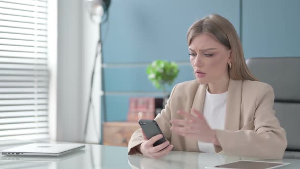 Upset Businesswoman Reacting to Loss on Smartphone