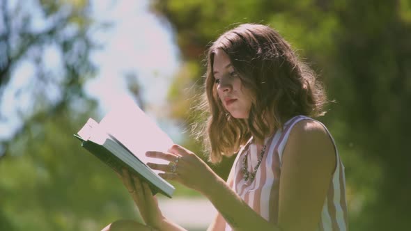 Concentrated Lady with Curly Hair Turns White Book Pages