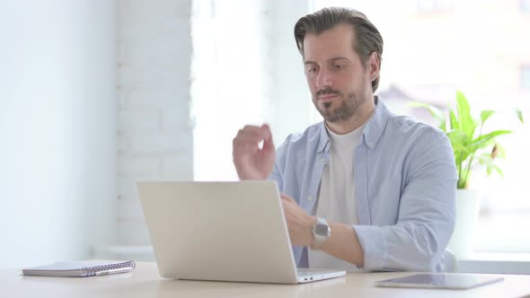 Young Man Having Wrist Pain While Using Laptop