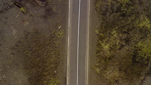 Narrow Road Between Rocky Soil Landscape In Reykjanes Iceland - aerial shot