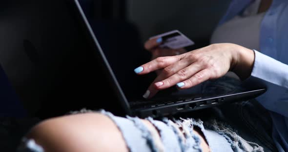 Woman Holding A Credit Card And Notebook Typing Credit Card Details