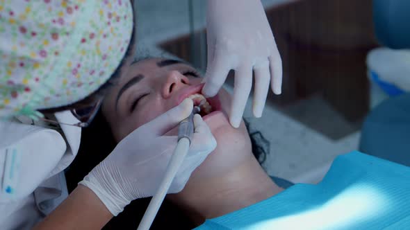 A Dentist is Doing an Oral Examination of His Young Woman Patient