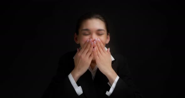 Funny Brunette Covers Her Mouth with Her Hands so As Not to Laugh Out Loud