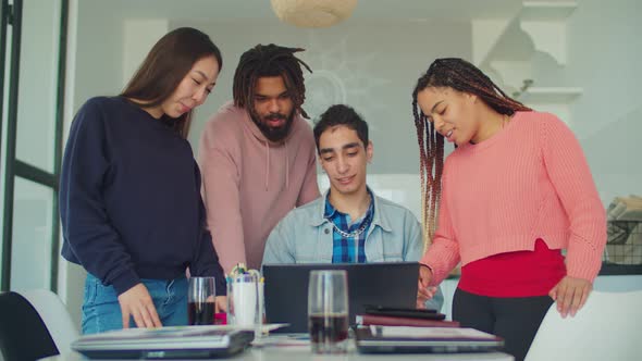 Creative Team Gathered Around Laptop at Home Office