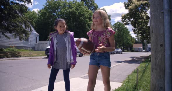 Girls and sports - friends walking with a football