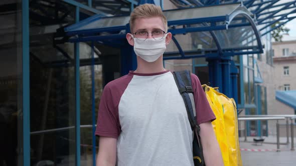 Rack Focus From Male Courier in Eyeglasses and Coronavirus Face Mask to Stretched Package with