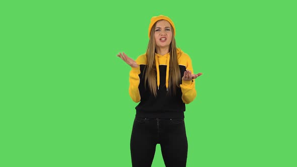 Modern Girl in Yellow Hat Is Reporting and Telling a Lot of Interesting Information. Green Screen