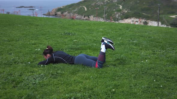 a Girl in Leggings Lies on Green Grass Makes a Mess for the Buttocks and Rubber