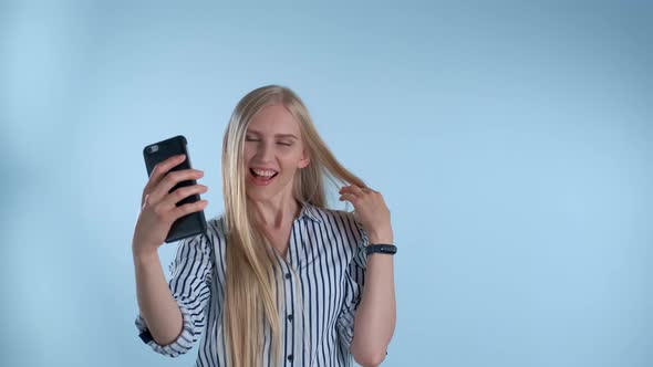 Attractive Blonde Lady Making Selfie on Smartphone on Blue Background