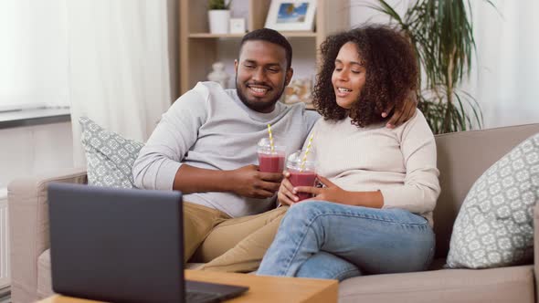 Couple with Laptop and Straw Drinks at Home