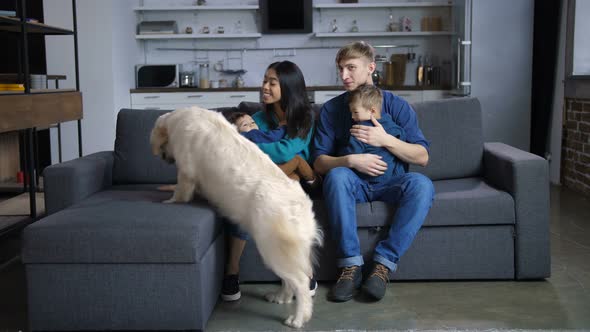 Multi Ethnic Family with Dog Relaxing on Sofa