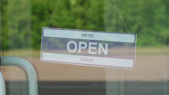 A Man Changes a Sign That Says OPEN for a Sign That Says CLOSED During the COVID19 Pandemic