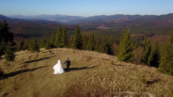 Aerial View Beautiful Couple Walking Against in the Mountains of the Carpathians