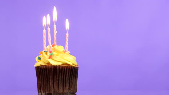 Tasty Birthday Cupcake with Four Candle, on Purple Background. Going Out
