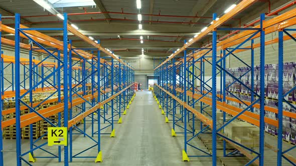 Forwarding drone shot inside warehouse empty racks, France