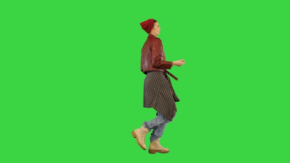 Young Girl in Stylish Urban Clothes Walks Dancing Slightly Snapping Fingers on a Green Screen Chroma