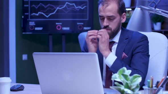 Exhausted Man in Formal Suit Works on the Laptop