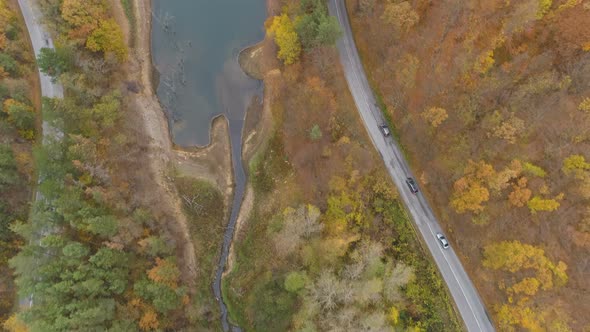 Drone Following Cars Driving on Dangerous Road in the Mountains Near Lake