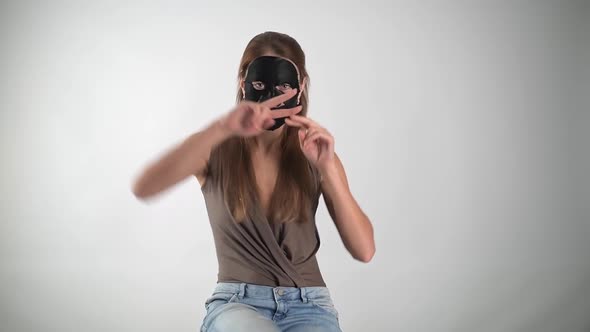 Young Pretty Girl on a White Background in a Black Mask to Moisturize the Face