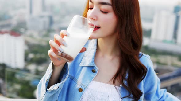 Attractive Asian woman drinking milk