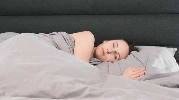 Woman sleeping on bed alone.