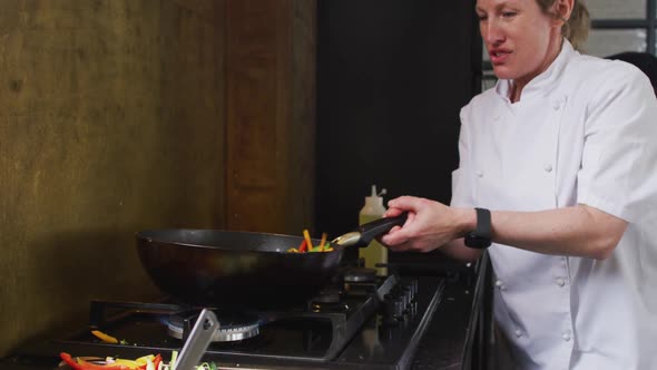 Caucasian female chef teaching diverse group preparing dishes and smiling