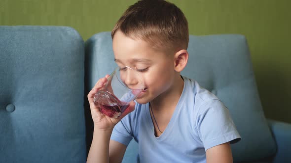 A Little Boy Drinks Juice