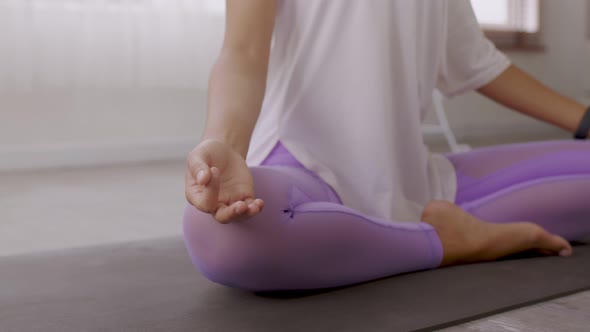 After waking up at home, a woman does morning yoga
