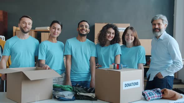 Slow Motion Portrait of Charity Company Employees Standing with Donation Boxes Smiling in Office