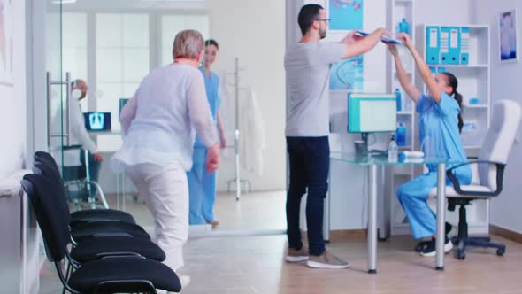 Young Man Filling Documents in Hospital Waiting Area