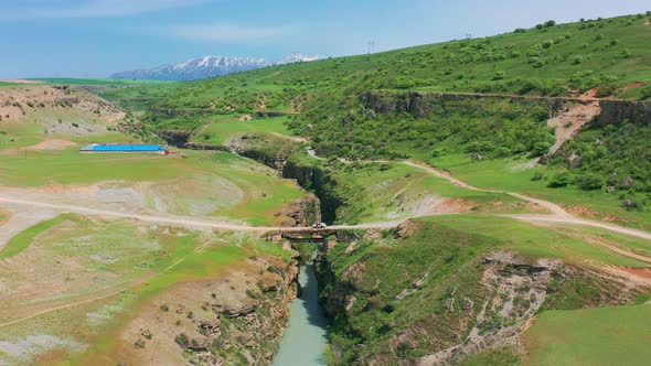 Aerial View on Metal Bridge and Car with Tourists Over Deep Canyon Aksu Kazakhstan