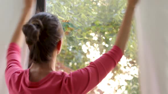 Woman Against Window Closing Curtains