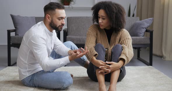 Couple Quarrelling Sitting on Floor Near Couch at Home, Desperate Afro Girlfriend Crying Feel Sad