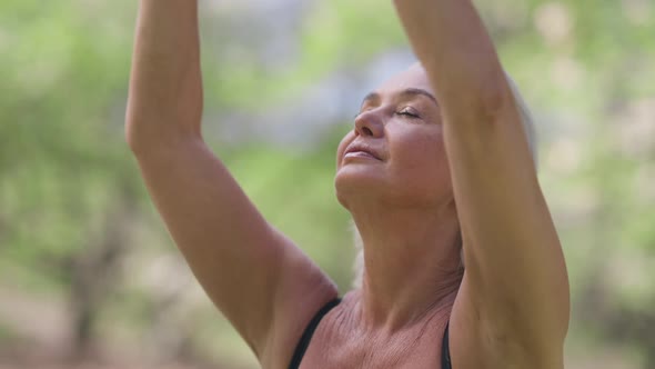 Closeup of Confident Slim Fit Retiree Meditating in Lotus Pose Closing Eyes