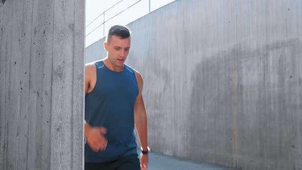 Young Man Running and Checking Smart Watch in City