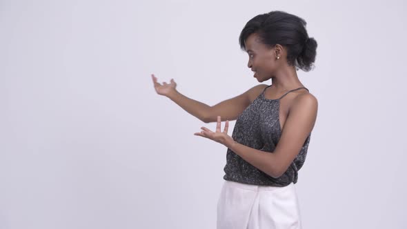 Happy Young Beautiful African Woman Showing Something and Ready To Party