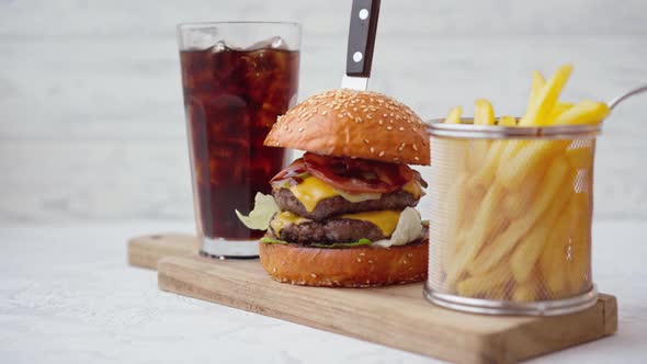 Fresh Tasty Burger Served with Soda and French Fries on White Table