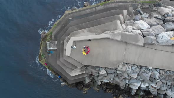 People forming circle on cliff building