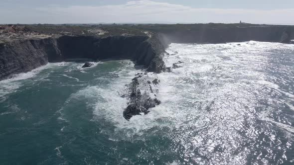 Aerial view of black cliffs in strong waves in 