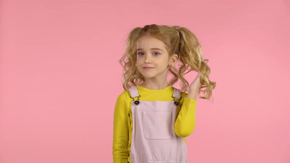 Beautiful Sweet Little Girl Is Playing with Her Hair