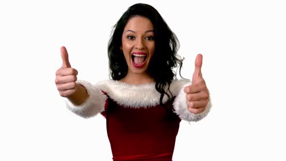 Pretty brunette in santa outfit showing thumbs up