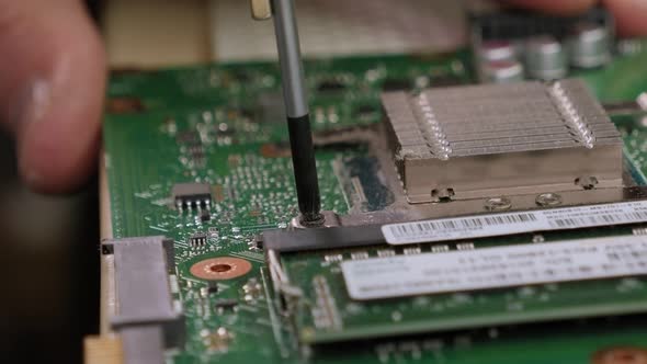 Young Male Tech or Engineer Repairs Electronic Equipment in Research Facility